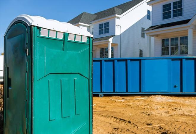 a row of portable toilets on a bustling job site